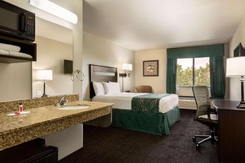 a hotel room with a bed and a sink at Travelodge by Wyndham Santa Teresa in Santa Teresa