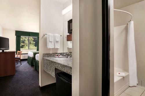 a bathroom with a sink and a mirror at Travelodge by Wyndham Low Moor Near Covington in Low Moor