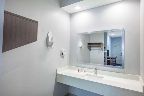 a bathroom with a sink and a mirror at Baymont by Wyndham Houston Hobby Airport in Houston
