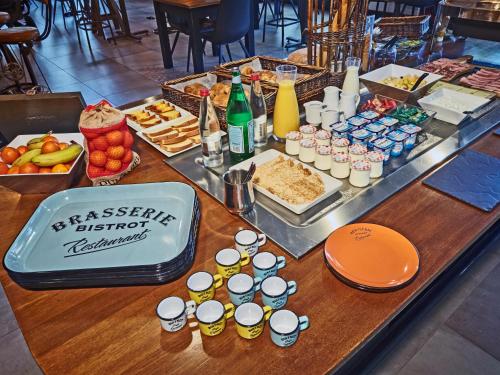 Kyriad Lille Est - Hem في Hem: طاولة مع بوفيه من المأكولات والمشروبات