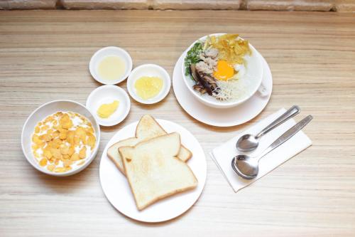 a table with two plates of food with eggs and toast at Get Zleep Premium Budget Hotel in Chiang Mai