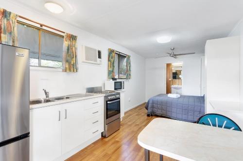a kitchen with a sink and a bed in a room at First City Caravilla in Cairns