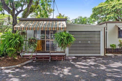 a house with a gate and a garage at First City Caravilla in Cairns