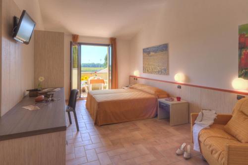 una habitación de hotel con una cama y un sofá en Le Fiabe Hotel Resort, en Numana