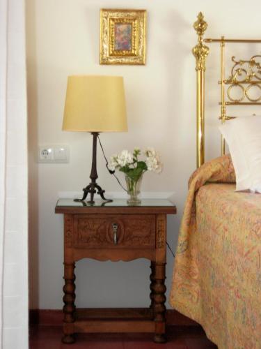 a lamp on a table next to a bed at Hotel Santa Isabel La Real in Granada