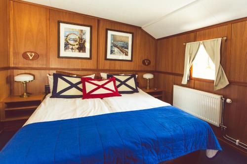 a bedroom with a blue bed in a boat at Hotel Barken Viking in Gothenburg