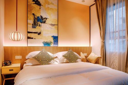 1 dormitorio con 1 cama con 2 almohadas en Huizhou Xilin West Lake Boutique Hotel, en Huizhou