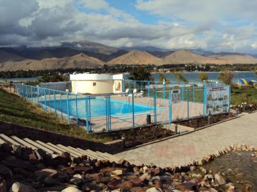 Tri Korony في شولبون آتا: مسبح وحوله سياج بجانب سفح ماء