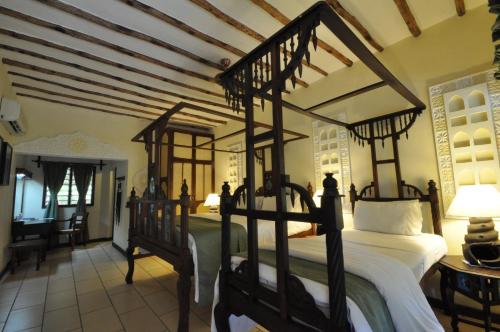 a bedroom with a four poster bed in a room at Kilifi Bay Beach Resort in Kilifi