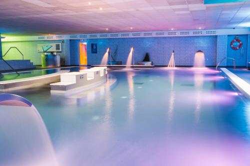 a swimming pool in a gym with purple lights at Apartamentos Alday in Maliaño
