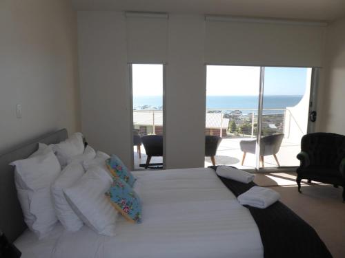 a bedroom with a bed with a view of the ocean at Bridport Horizon Views in Bridport