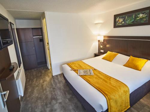 a hotel room with a large bed and a television at Kyriad Lille Est - Hem in Hem