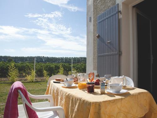 une table avec un chiffon de table jaune et des boissons dans l'établissement Vacancéole - Le Domaine d'Enserune, à Colombiers