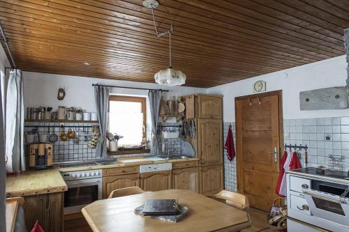 a kitchen with a wooden ceiling and a table in it at Rauriser Bergchalet in Rauris