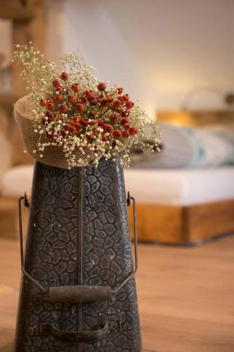 a black vase with flowers and a hat on top at Rauriser Bergchalet in Rauris