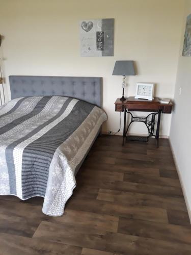 a bedroom with a bed and a nightstand with a table at De Groote Medwert in Holwerd