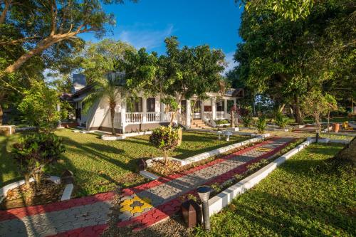 a house with a garden in the yard at Warmth Lake Haven in Alleppey