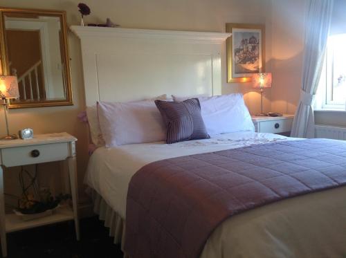 a bedroom with a bed and two lamps and a mirror at Annandale House in Dublin