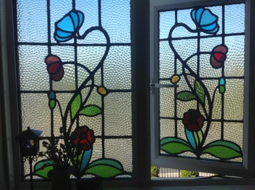 a stained glass window with flowers on it at Annandale House in Dublin