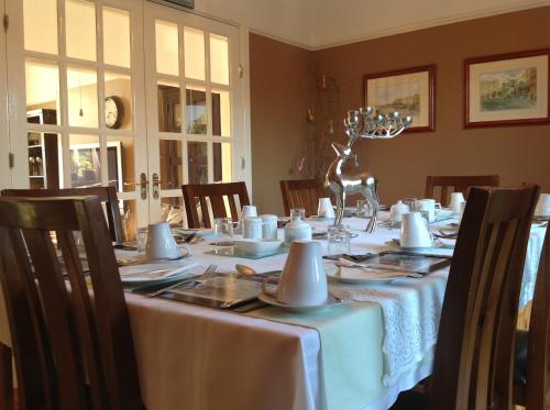 uma sala de jantar com uma mesa com uma toalha de mesa branca em Annandale House em Dublin