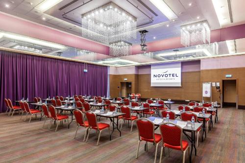 a banquet hall with tables and red chairs at Novotel Trabzon in Trabzon