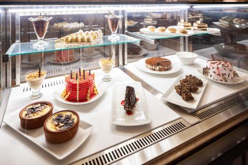 a display case with different types of cakes and desserts at Novotel Trabzon in Trabzon