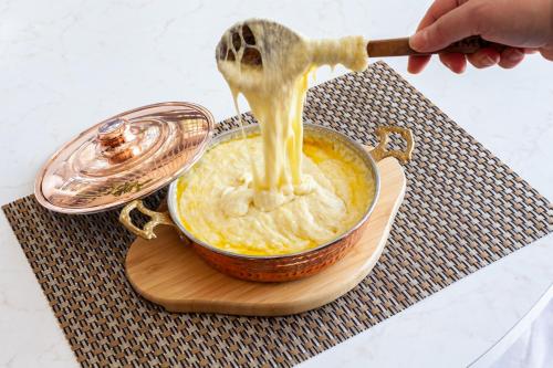 a person is pouring food into a pot of food at Novotel Trabzon in Trabzon