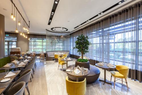 a restaurant with tables and chairs and windows at Novotel Trabzon in Trabzon