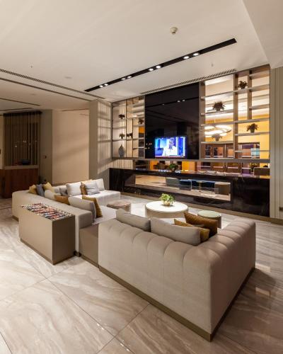 a living room with couches and a flat screen tv at Novotel Trabzon in Trabzon