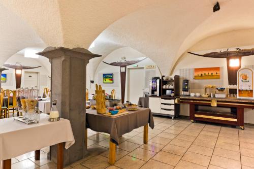 a restaurant with arches and tables and a kitchen at Les Hirondelles in Orcines