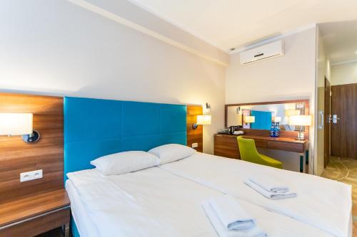ミエンジズドロイェにあるRent like home - Hotel Room 203のベッドルーム1室(大型ベッド1台、青いヘッドボード付)