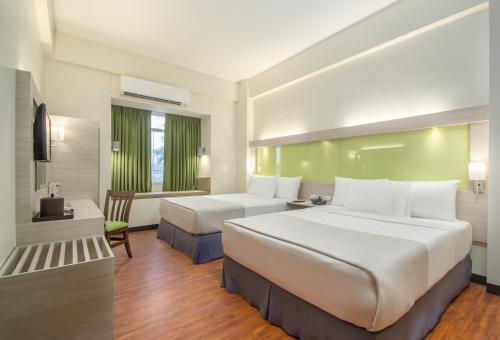 ein Hotelzimmer mit 2 Betten und einem Schreibtisch in der Unterkunft Microtel Inn & Suites by Wyndham San Fernando in San Fernando