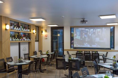 a restaurant with tables and chairs and a large screen at B&B Nataly 2 in Soko Banja