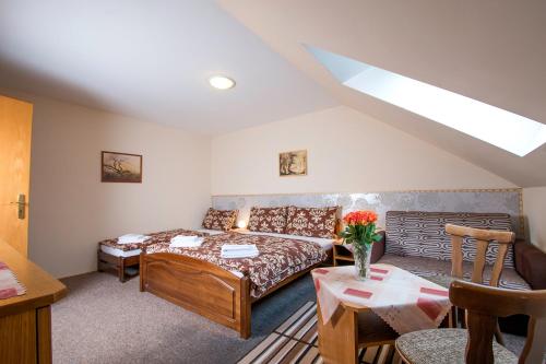 Zimmer mit einem Bett, einem Sofa und einem Tisch in der Unterkunft Rodinný hotel Myslivna in Třeboň