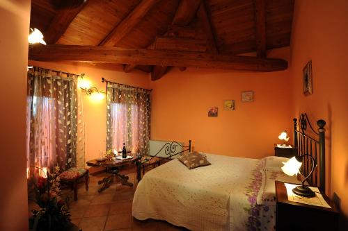 Agriturismo Bianconiglio في مونفورتي دالبا: غرفة نوم بسرير وطاولة ومكتب