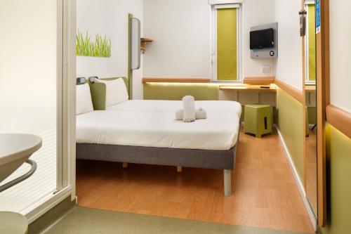 a small room with a bed and a sink at ibis Budget Manchester Centre Pollard Street in Manchester