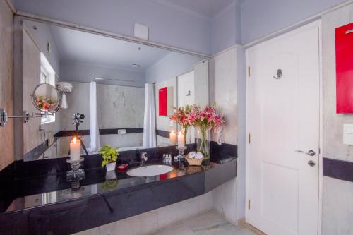 uma casa de banho com um lavatório e um espelho grande em Colonel's Retreat 2 em Nova Deli
