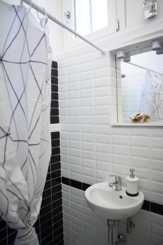 a white bathroom with a sink and a mirror at Villa Giove Rooms in Prato