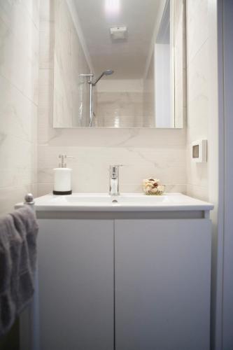 a white bathroom with a sink and a mirror at Villa Giove Rooms in Prato