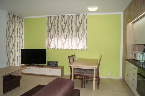 a living room with a table and a television at Apartments Klinovec in Loučná pod Klínovcem