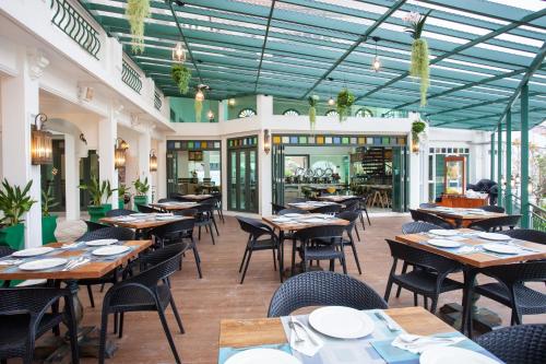 a restaurant with tables and chairs in a room at Supicha Pool Access Hotel - SHA Plus in Phuket Town