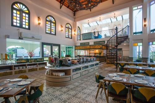 a restaurant with tables and chairs and a staircase at Supicha Pool Access Hotel - SHA Plus in Phuket Town