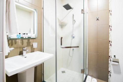 a bathroom with a sink and a shower at Elegant Hotel & Resort in Tsaghkadzor