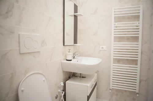 a white bathroom with a toilet and a sink at Villa Giove Rooms in Prato