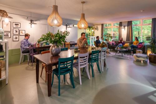 people are gathered around a dining room table at Stayokay Hostel Arnhem in Arnhem
