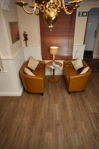 a living room with two couches and a table at Best Western The George Hotel, Swaffham in Swaffham