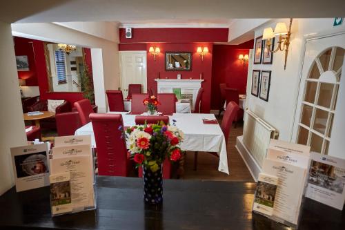 a restaurant with a table with a vase of flowers at Best Western The George Hotel, Swaffham in Swaffham