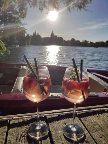 zwei Weingläser auf einem Tisch auf einem Boot in der Unterkunft Pension Seeschlösschen in Mölln