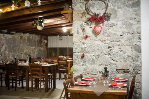 un ristorante con tavoli e sedie e un muro di pietra di Agriturismo La Pedruscia a Civo