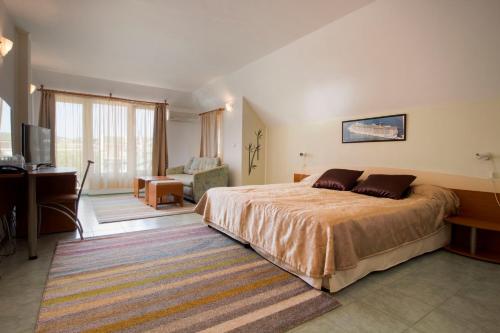 um quarto com uma cama grande e uma secretária. em Family Hotel Venera em Sveti Vlas